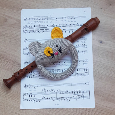 Crocheted cat rattle with a yellow ear