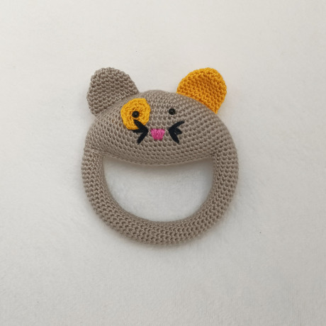 Crocheted cat rattle with a yellow ear